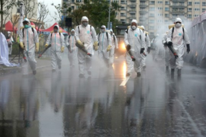 Image: Taiwanese army soldiers wearing protective suits spray disinfectant over a road in New Taipei City, Taiwan, March 14th, 2020 (Source: AP photo by Chiang Ying-ying).