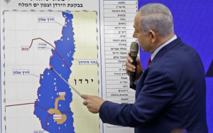 Image: Prime Minister Benjamin Netanyahu points at a map of the Jordan Valley, promising to extend Israeli sovereignty to the Jordan Valley (Source: Menahem Kahana/AFP)