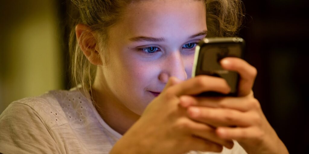 Pildil tüdruk mobiiliga